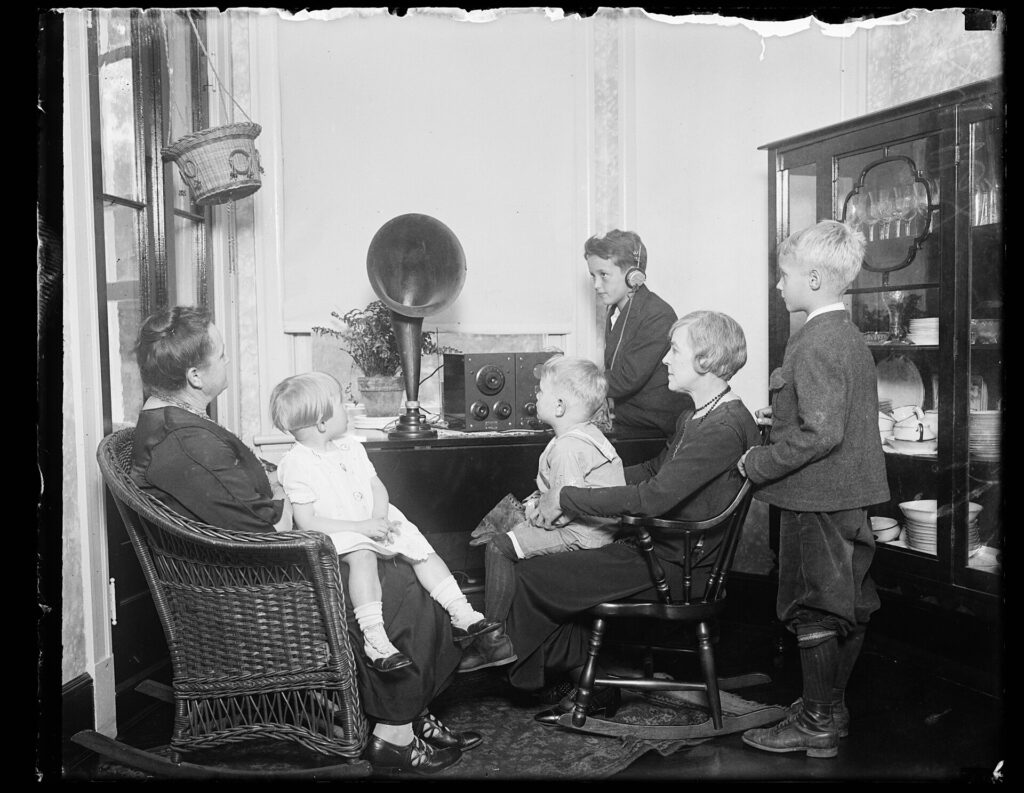 A family gathered around an early radio receiver in 1921.