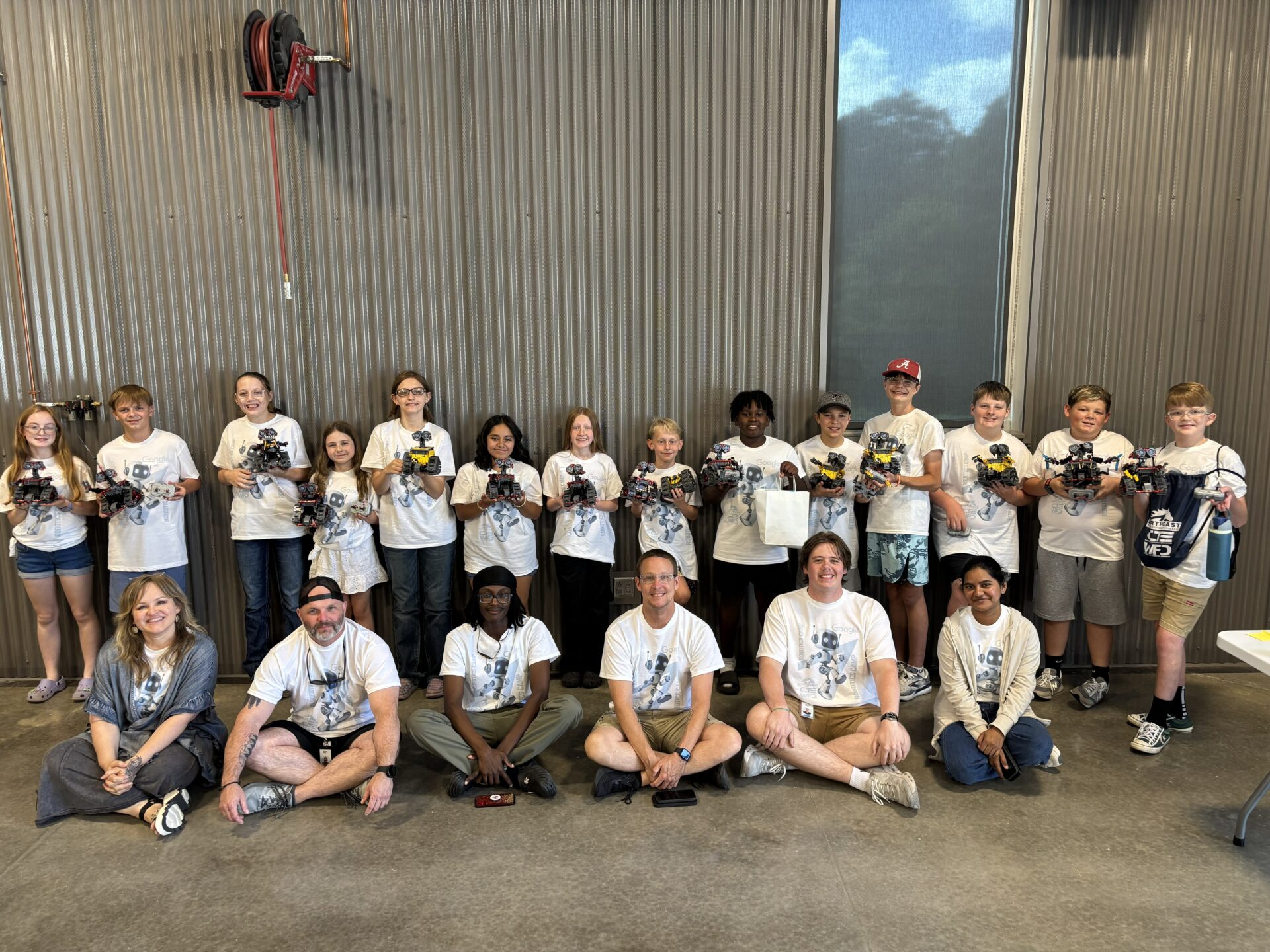 Students and adult mentors display remote-controlled robots built during the Google-sponsored summer robotics camp at Northeast Alabama Community College.