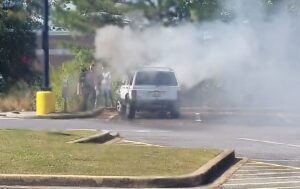 Firefighters spray water toward a vehicle surrounded by smoke during the Centre Walmart vehicle fire response.