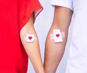 Two people wearing white bandages with red hearts on their arms in a photo illustrating Gadsden blood drives.