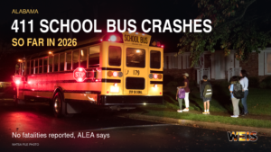 Stopped school bus with red warning lights and children nearby beneath an Alabama school bus crashes headline.