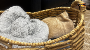 Gray and tan blankets in a woven basket illustrating the Cherokee County Children’s Advocacy Center’s blanket donations appeal.