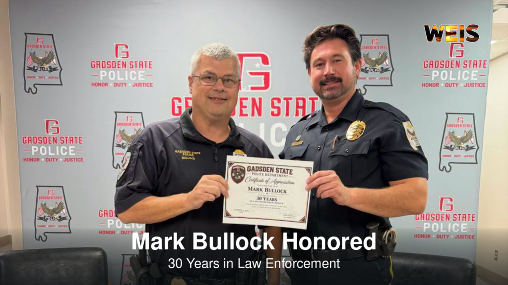 Officer Mark Bullock, left, holding a certificate recognizing 30 years in law enforcement at Gadsden State.