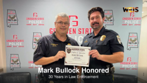 Officer Mark Bullock, left, holding a certificate recognizing 30 years in law enforcement at Gadsden State.