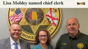 Lisa Mobley, center, pictured with two men at the Cherokee County Sheriff’s Office in a header announcing her chief clerk promotion.