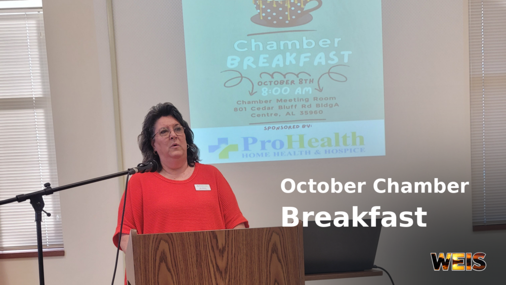  Jan Martin of ProHealth speaks at the Cherokee Chamber breakfast in Centre, with the event and sponsor projected behind her.