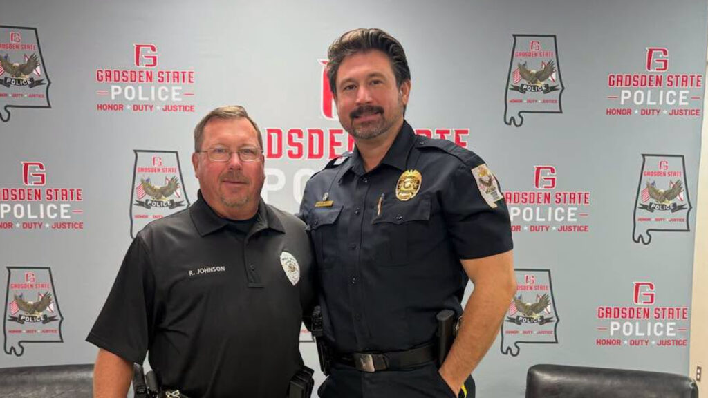 Richard Johnson, left, with Chief Jay Freeman in front of a Gadsden State Police backdrop.